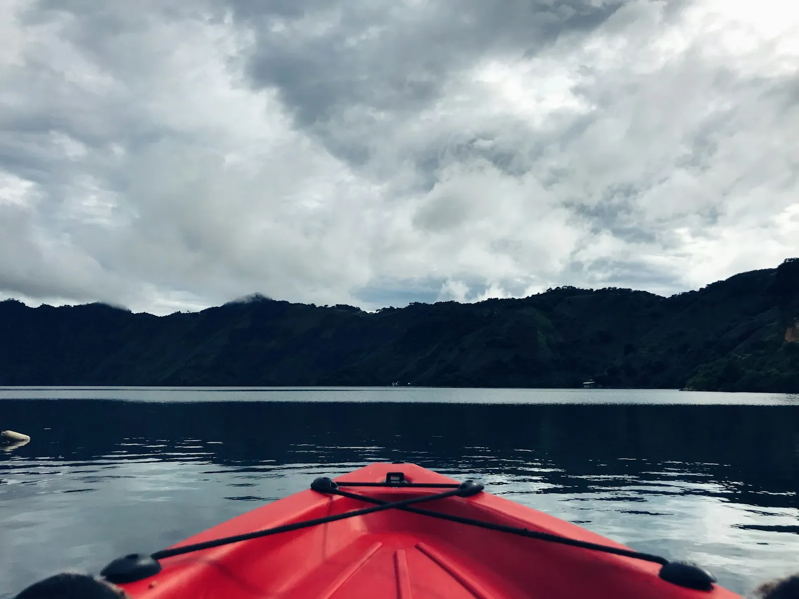 A kayaker gliding across still water at dawn