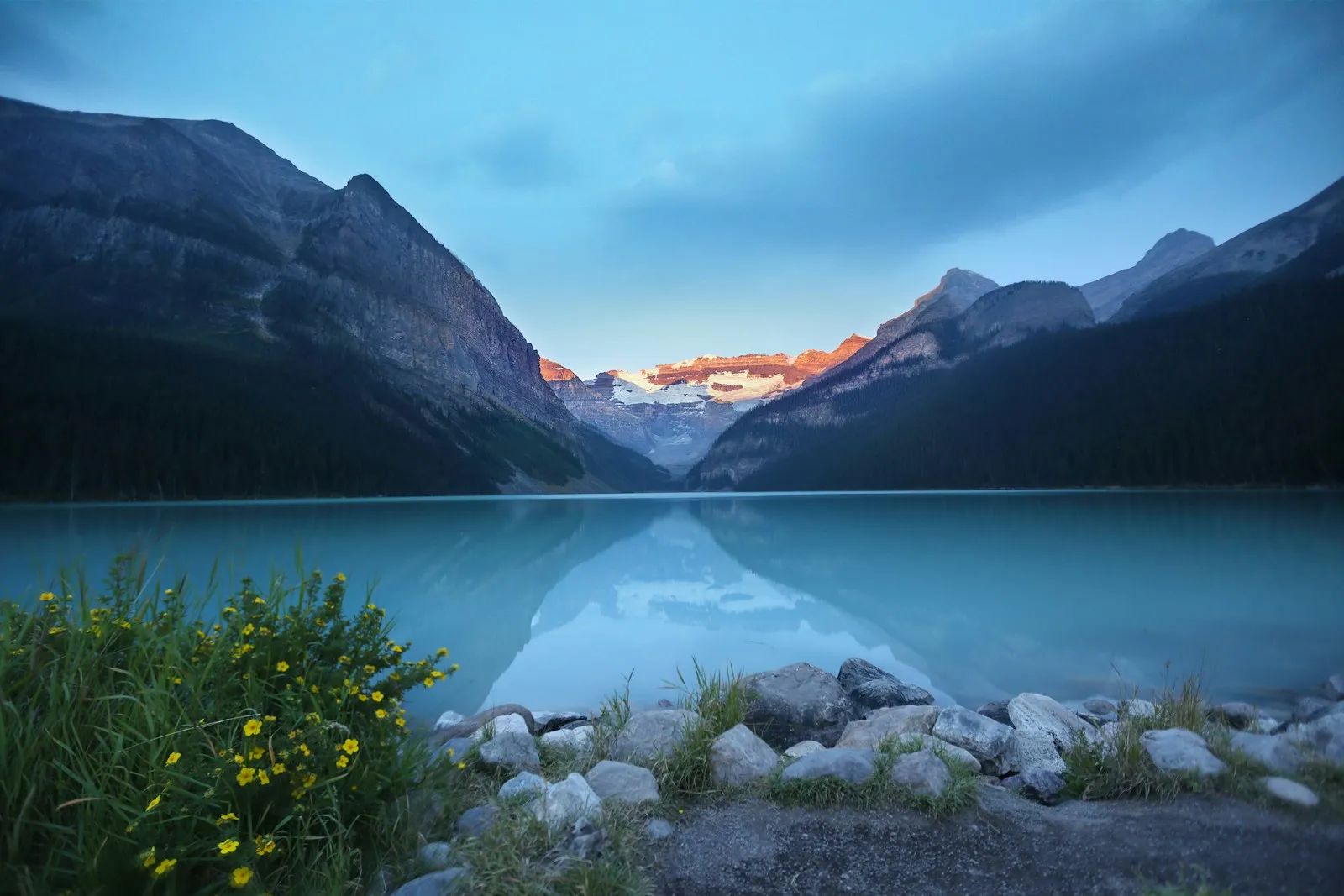 An alpine lake glowing under a dusk sky