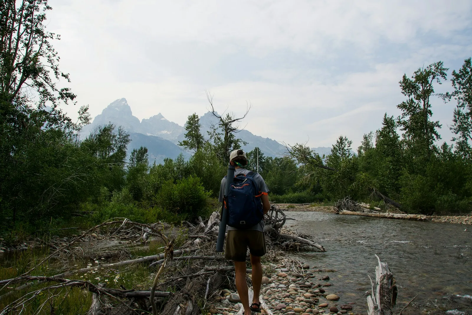 Hikers linking arms to cross a shallow mountain river