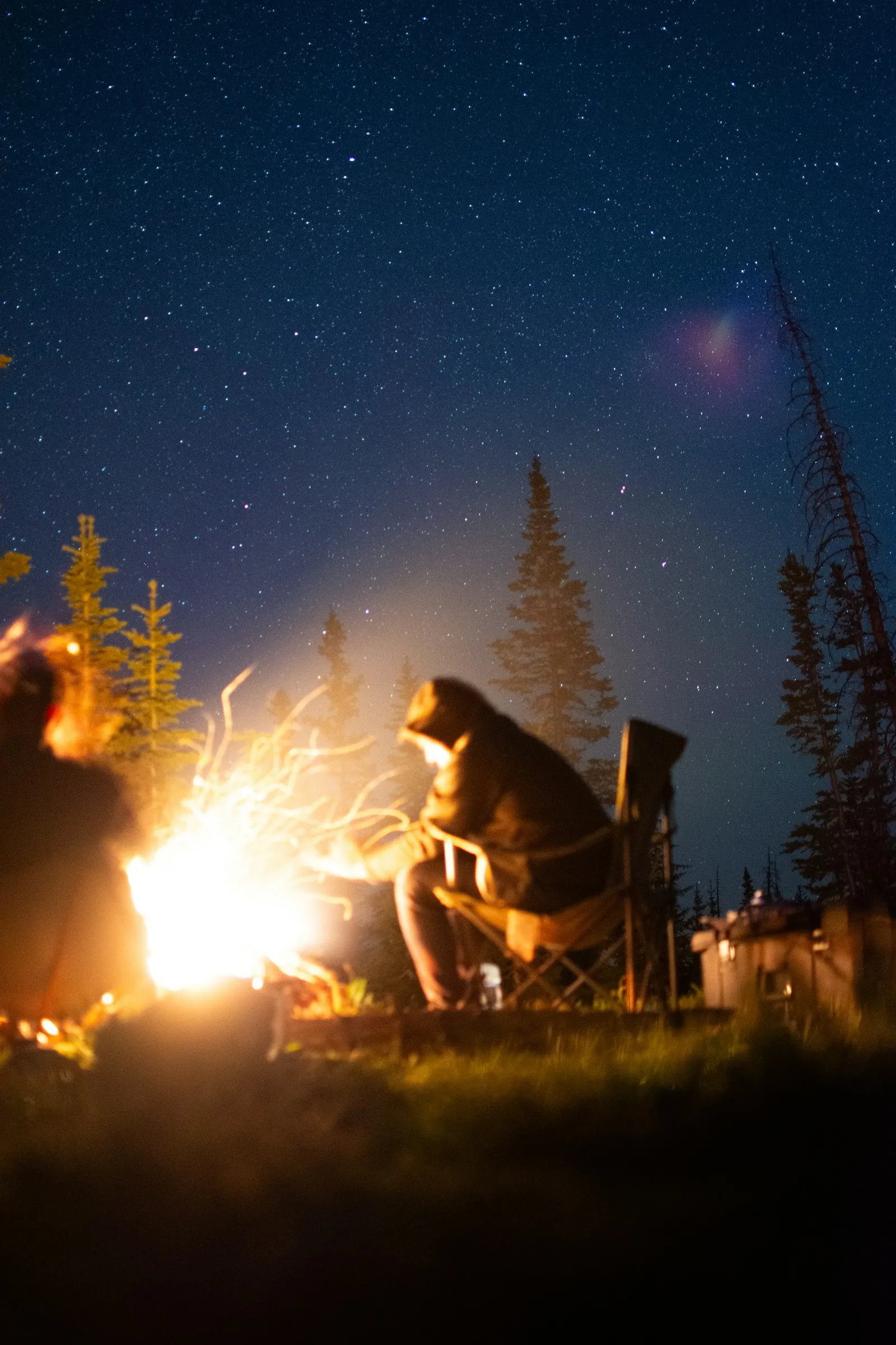 Guides gathered around a basecamp fire at dusk